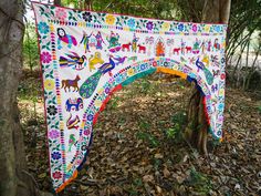 an arch decorated with animals and flowers in the middle of some leaves on the ground