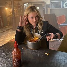 a woman sitting at a table with a bowl of food