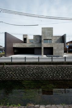 the concrete building is next to a body of water