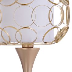 a gold lamp with a white shade on it's base and a circular design