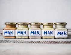 five jars with different types of spices in them