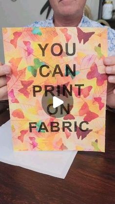 a man holding up a sign that says you can print on fabric