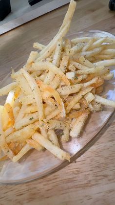 french fries are piled up on a glass plate