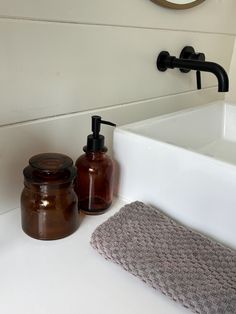 a bathroom sink with soap dispenser and towel