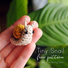 tiny crocheted llama with an orange flower on its head sitting in someone's hand