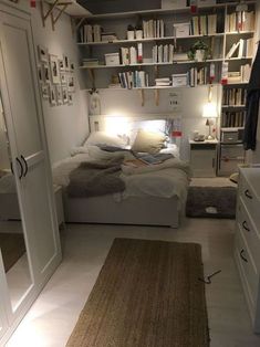 a bed room with a neatly made bed and bookshelves