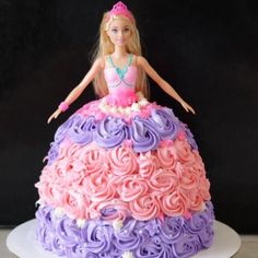 a barbie doll cake with pink and purple frosting