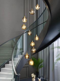 a spiral staircase with glass balls hanging from the ceiling and stairs leading up to it