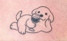 a small tattoo of a dog holding a glass of wine with its paw in it's mouth