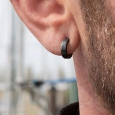 a close up of a man wearing an earring