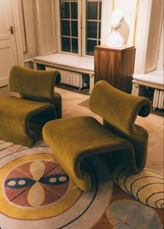 two green chairs sitting on top of a rug in a living room