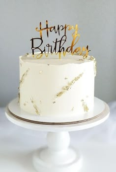 a white cake with gold letters and sparkles