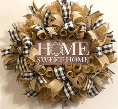 a wreath with the words home sweet home written on it and some ribbons around it