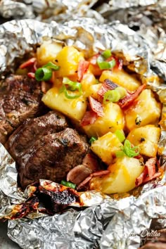 steak, potatoes and peppers on foil with green onions in the middle for garnish