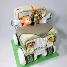 a toy car with stuffed animals in the back and on the front, sitting on top of a green mat