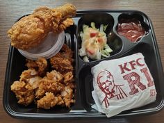 a tray with chicken, coleslaw and ketchup on it