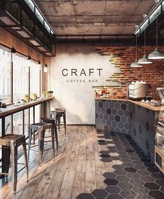 the interior of a restaurant with wooden floors and brick walls, an open kitchen area