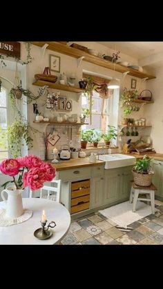 a kitchen filled with lots of green cupboards and white dishes on top of wooden shelves