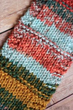 a multicolored knitted dishcloth laying on top of a wooden table