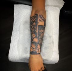 a person with a cross tattoo on their arm and foot is sitting in front of a towel