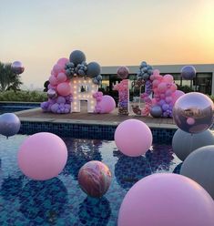 balloons floating in the air near a swimming pool with an i love sign on it