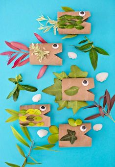 some paper bags with plants on them and eyes in the middle, sitting on a blue surface