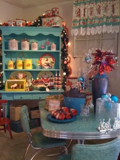 a dining room table covered in plates and bowls with christmas decorations on the top shelf