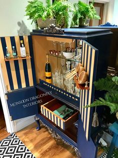 a blue cabinet with wine glasses and bottles in it