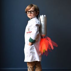 a little boy dressed as a chef holding a rocket