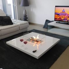 a living room with a white coffee table in front of a flat screen tv