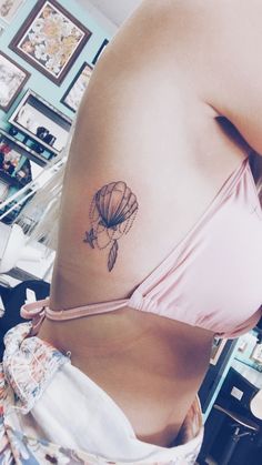 a woman's stomach with a tattoo on the side of her belly and an image of a hot air balloon