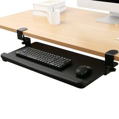 a computer desk with a keyboard, mouse and monitor sitting on it's stand