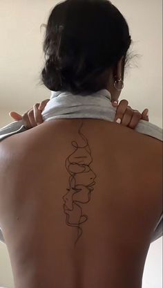 a woman with a tattoo on her back holding a pair of scissors to her neck