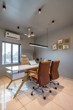 a room with a table, chairs and pictures on the wall in front of it