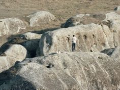 a man standing on top of a large rock formation