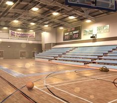 an empty gym with basketballs on the floor and lights in the ceiling for fans to see