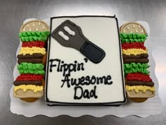 a birthday cake that says flippin'awesome dad on the side with a knife and hamburger