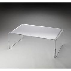 an acrylic coffee table with clear legs and a glass top, on a grey background