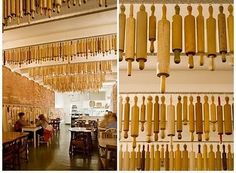 the inside of a restaurant with lots of wooden objects hanging from the ceiling