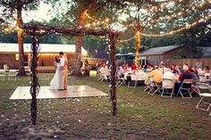 a bride and groom share their first dance under the gazebo at their wedding reception