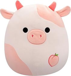 a white and pink pig pillow with an apple on it