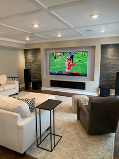 a living room filled with furniture and a flat screen tv mounted to the side of a wall