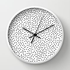 a white clock with black dots on it