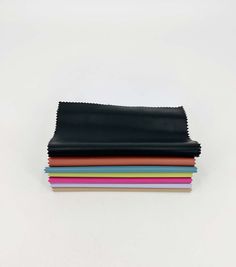 four different colors of leather are stacked on top of each other, with one folded in half