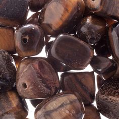 several wooden beads are shown together on a white surface and one is brown, the other has black spots