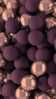 an array of shiny balls in purple and gold colors are shown as if they were floating or floating on water