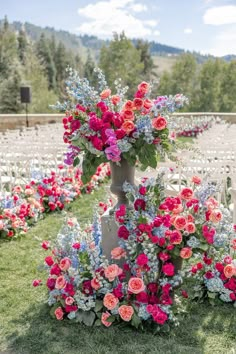 an outdoor ceremony setup with flowers and greenery