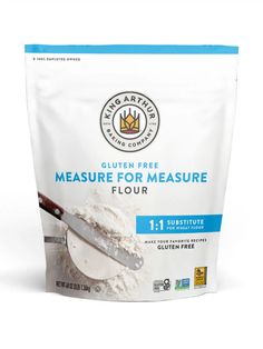 a bag of flour sitting on top of a white counter next to a measuring spoon