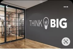 think big wall decal in an office with wooden floors and glass doors that read think big