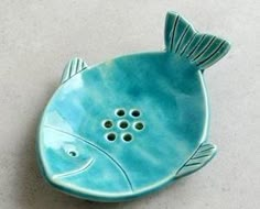 a blue fish shaped dish sitting on top of a white countertop next to a wall